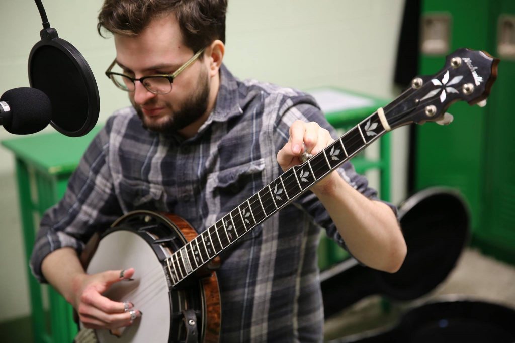 Discussing and tuning banjo while in the studio for the radio. Music Lessons page